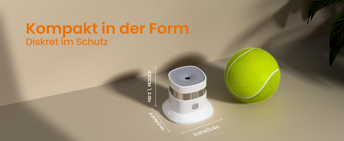 Heiman HS1SA-M Rauchmelder, kompakt in der Form und diskret im Schutz, mit den Maßen 6,0 cm x 6,0 cm x 4,92 cm, gezeigt neben einem Tennisball.